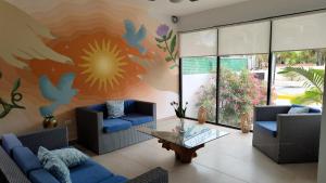 莫雷洛斯港Vela's Condos Ocean Front的客厅配有蓝色的沙发和花卉壁画
