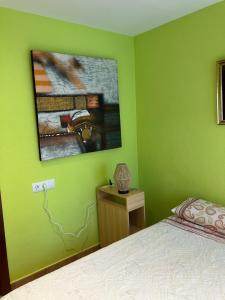 L’ EsquirolL'Esquirol de L'Esquirol的一间绿色卧室,配有一张床和墙上的照片