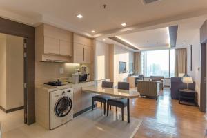 曼谷曼谷茉莉花度假酒店的厨房以及带洗衣机和烘干机的客厅。
