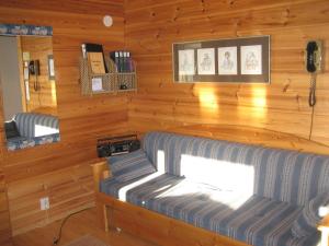 阿卡斯洛姆波罗库尔卡尔提奥度假村的小屋内带沙发的客厅