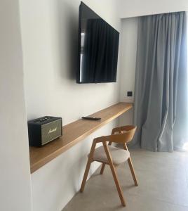 普拉迪斯亚罗斯Mykonos Drops的一张桌子、椅子和墙上的电视
