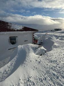 VíðirhóllGrímstunga Guesthouse Hólsfjöll的雪覆盖的房屋,屋顶