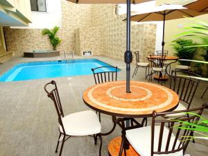 萨利纳斯马尔温托套房酒店的一个带桌椅的庭院和一个游泳池