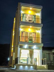 鹅銮鼻蒂棻尼旅店的一座黄色的大建筑,晚上设有阳台