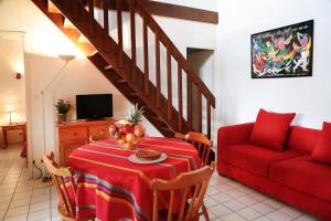 布科·莱斯白老城阿基坦公寓的客厅配有桌子和红色沙发