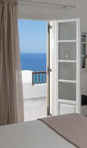 MoutsoúnaEvdokia - Luxury Olive Yard apartment with Aegean View的一间卧室设有一扇通向大海的门