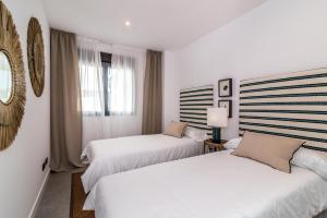 EsteponaEstepona Holiday Hills的配有白色墙壁的酒店客房内的两张床