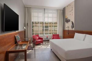 都灵灵格托都灵国会NH酒店的酒店客房,配有床和电视