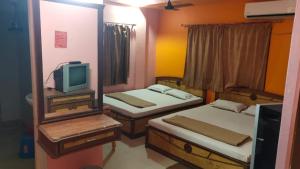 迪卡Hotel Sunny New Digha Near Sea Beach View Point - Couple Friendly的小房间设有两张床和电视