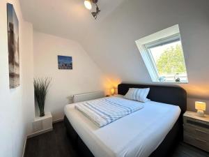 达格比尔Haus Monika的卧室配有一张大白色床和窗户