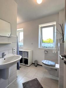 达格比尔Haus Monika的一间带水槽和卫生间的浴室以及窗户。