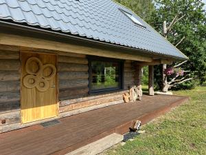 ReinaLepikumäe Holiday Home with Sauna and Hot tub for up to 16 persons的小木屋设有木门和甲板