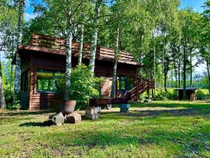 ReinaLepikumäe Holiday Home with Sauna and Hot tub for up to 16 persons的森林中间的小木屋