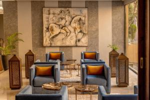 马拉喀什马拉喀什瑞德酒店的大堂设有桌椅和一幅马画
