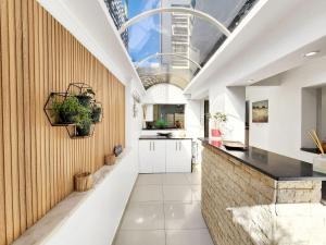 开普敦Urban Style House with Jacuzzi & Garage的厨房配有白色橱柜和黑色柜台。