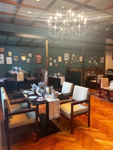 巴特贝特里希Vintagehotel Adler的一间带桌椅和吊灯的用餐室