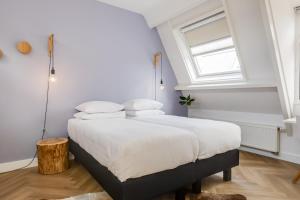 登博斯Achter de Kan的一间卧室配有一张带白色床单的床和一扇窗户。