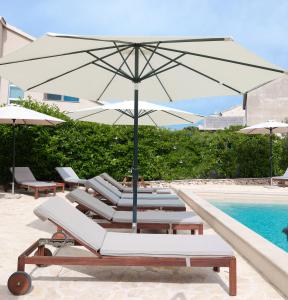 布罗达里卡Laura Apartments的一组躺椅,在游泳池畔配有遮阳伞