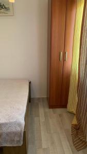 苏沙尼Apartmani Green Olive的一间卧室配有一张床和一个木制橱柜