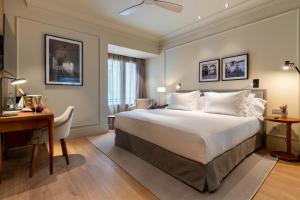 科尔多瓦H10 Palacio Colomera的酒店客房配有一张床、一张书桌和一张书桌。