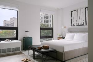 长岛市Sonder Court Square的卧室配有白色的床和2扇窗户。