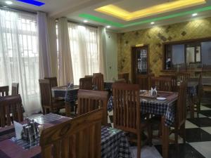 阿鲁沙Aves Executive Hotel的用餐室设有桌椅和窗户。