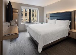 纽约纽约切尔西快捷假日酒店的一间卧室设有一张大床和一个窗户。