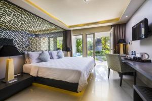 沙努尔萨伽拉田园酒店的一间卧室配有一张床、一张书桌和一台电视