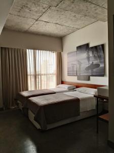 纳塔尔9006 Suites Natal Hotel的一间卧室设有两张床和窗户。