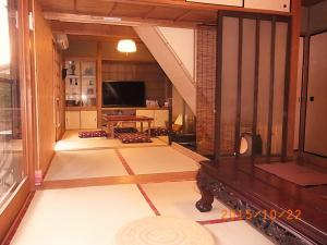 京都禅林寺三休荘町家度假屋的一间带电视和桌子的客厅