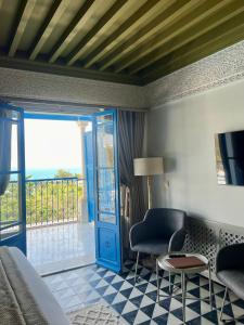 西迪·布·赛义德La Menara Hotel & SPA的一间卧室设有一张床,另一扇门设有阳台