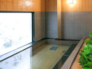 滨松滨松迪乐多利酒店的带窗户的客房内的热水浴池