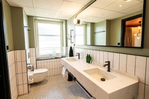 卡尔斯塔德Hotel Fratelli的一间带水槽、卫生间和镜子的浴室
