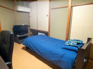 高松Takayanagi Ryokan - Vacation STAY 88522v的一间卧室配有一张床和一台电视