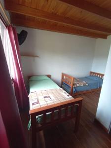 吉亚迪诺镇Del Carmen的小房间设有两张床和一张桌子
