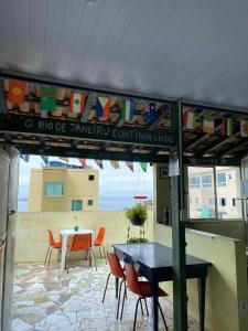 里约热内卢Hostel Alzira House Vidigal的庭院配有桌椅、桌子和桌子