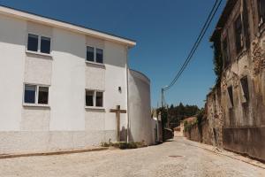 法局兹斯Casa da estrela Albergue Caminho de Santiago的白色建筑前的一条空的街道