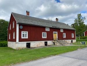 BäckeforsBäckefors vandrarhem的红色谷仓,旁边有一扇黄色门