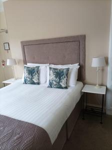 基拉尼翠鸟旅馆的一间卧室配有一张大床和两个枕头