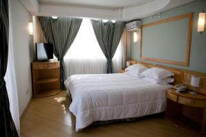 瓜拉普阿瓦阿塔拉亚帕拉斯酒店的酒店客房设有一张床和一个大窗户