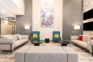 多伦多多伦多机场桑德曼签名酒店的大堂配有沙发、椅子和电视。