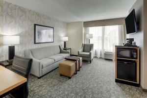 伯明翰Drury Inn & Suites Birmingham Lakeshore Drive的一间客厅,客厅配有沙发和电视,位于酒店的房间