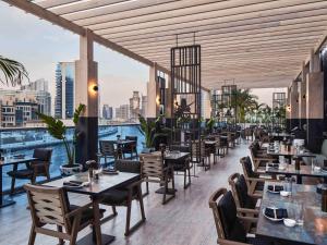 迪拜Hyde Hotel Dubai的一间带桌椅的市景餐厅