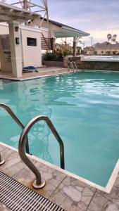 道伊斯G Hotel的一座房子前面的蓝色海水游泳池