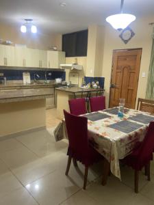 巴克里索莫雷诺港Casa de Alojamiento Muyuyo House的一间带红色椅子和餐桌的厨房以及一间用餐室