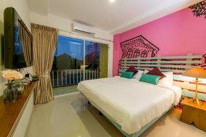 普吉镇福皮带普吉岛旅馆的一间卧室设有一张大床和一个大窗户