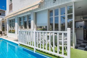 阿吉亚玛丽娜伊拉多酒店的一座带游泳池和白色围栏的房子