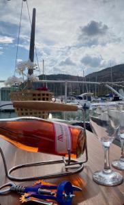 巴塞罗那Boat Barcelona Yacht的玻璃杯旁的桌子上放一瓶葡萄酒