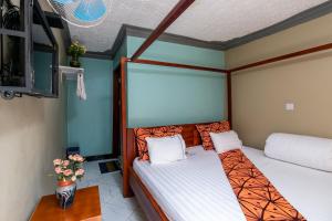 恩德培Haber Motel Enterprise Ltd的一间卧室设有两张单人床和一台电视机。