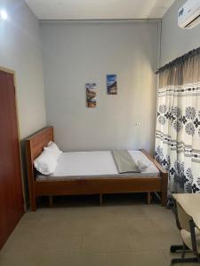 阿克拉Estepona Playa Hostel的一间带床和窗帘的小卧室